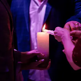 Hands lighting a candle during prayer in the Spragge community