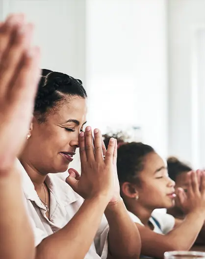 Congregation members praying together during a church service at Spragge Bible Church